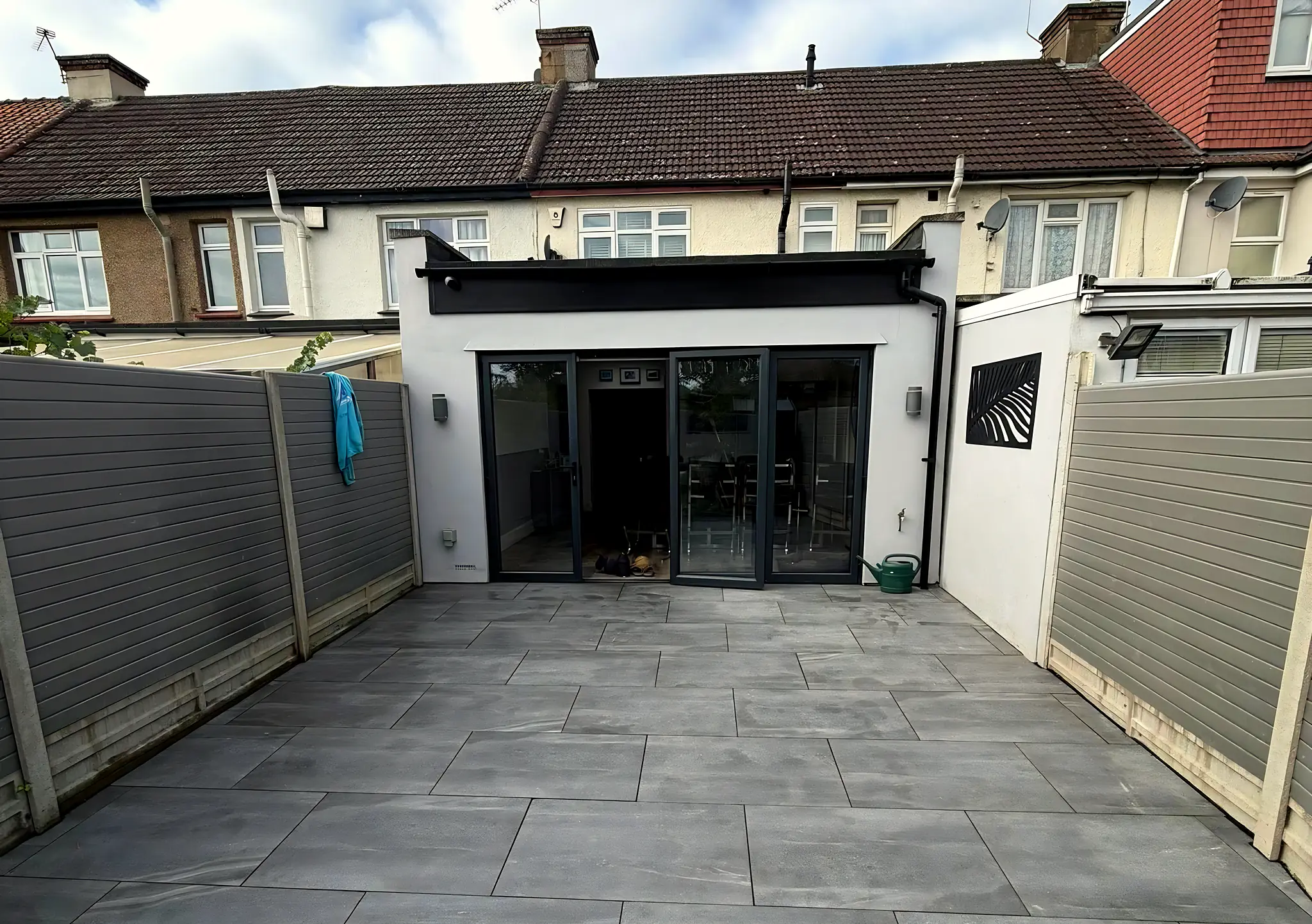 Grey porcelain patio leading to the bifold doors of a rear extension